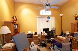 Large cluttered office with several desks. A professional organizer can help.