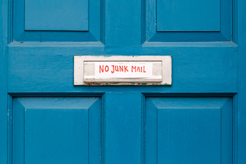 Blue door with handwritten sign over mail slot: No Junk Mail