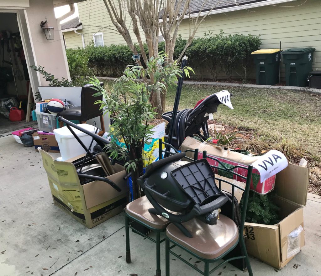 A pile of donations in a driveway including old chairs